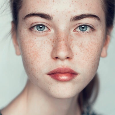 Actress Headshot with blue eyes brown hair.